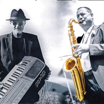 Zwei Musiker, einer mit Keyboard, der andere mit Saxophon.