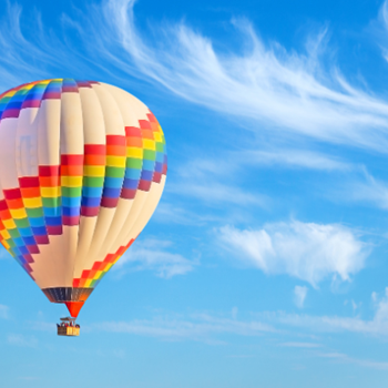Dem Alltag entschweben über dem Südburgenland Bunter Heißluftballon schwebt bei Sonnenschein über dem Südburgenland.
