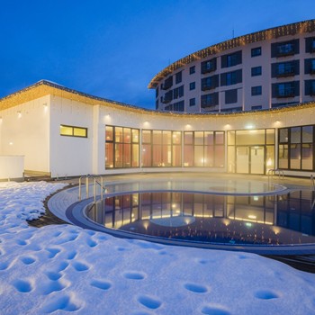Glanzvoll ins neue Jahr starten Beleuchteter Außenpool im verschneiten Innenhof des Allegria Resorts zur blauen Stunde.