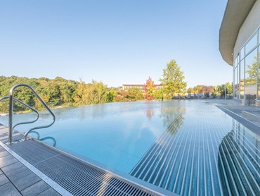 Außenpool des Allegria Resort Stegersbach mit Blick ins Grüne und moderner Architektur.