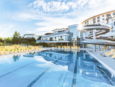 Badespaß unter freiem Himmel erleben Außenpool der Therme Stegersbach im Allegria Resort mit Sonnenterrasse und Rutschenanlage.