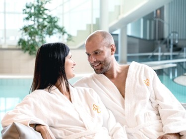 Paar im Bademantel am Pool der Therme Stegersbach im Allegria Resort.