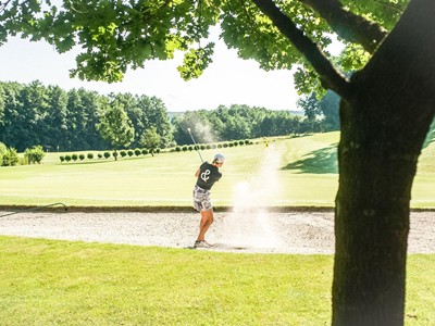 Golferin beim Bunkerschlag auf dem Golfplatz Stegersbach nahe dem Allegria Resort im Burgenland.