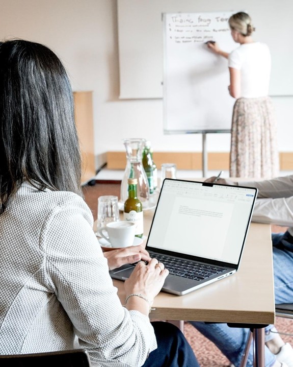 Der perfekte Raum für konzentriertes Arbeiten Zwei Teilnehmer bei einem Seminar im Allegria Resort Stegersbach, einer tippt auf einem Laptop, der andere Gast hört der Präsentation zu.